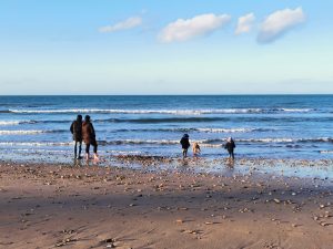 family with children by the sea in winter